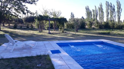 a swimming pool in a yard with a chair at Casa de campo Las olivas in San Rafael