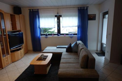 ein Wohnzimmer mit einer Couch und einem Couchtisch in der Unterkunft Barrierefreie Ferienwohnung mit Terrasse und überdachtem Grillplatz und Garten zur gemeinschaftlichen Nutzung in Osterbrücken