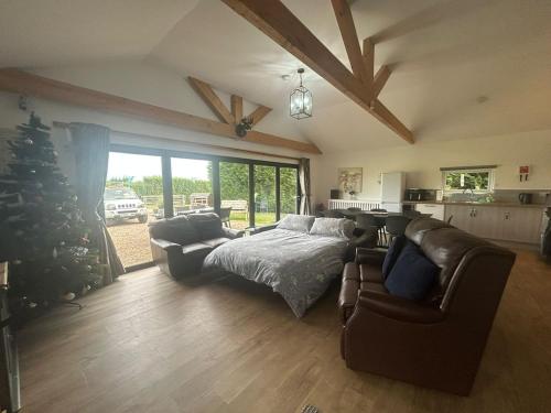 a living room with a bed and a christmas tree at King Richard's Luxury Lodge - Sleeps up to 8, Dog Friendly, Near Sherwood Forest at Fairview Farm in Nottingham set in 88 acres and great for Groups, Family Gatherings & Corporate events in Nottingham