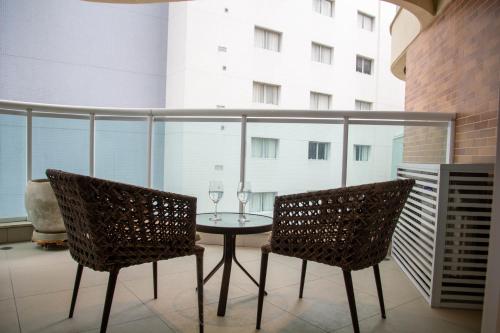 einen Balkon mit einem Tisch und 2 Stühlen in der Unterkunft BookSantos Estanconfor 1007 - Perto do mar Gonzaga in Santos