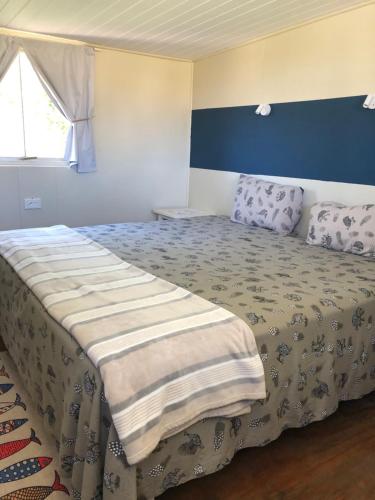 ein Schlafzimmer mit einem Bett mit einer Decke darauf in der Unterkunft VIssershuisies at Grootvlei Guest Farm 