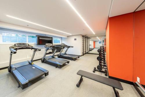 a gym with several tread machines in a room at BHomy Romana in Sao Paulo
