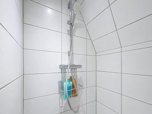 a shower in a white tiled bathroom at Le Toit Sahler-Château Sahler XXᵉ in Exincourt