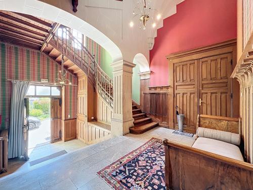 an ornate hallway with a staircase and a rug at Le Toit Sahler-Château Sahler XXᵉ in Exincourt