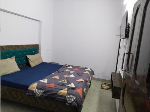 Un dormitorio con una cama con un edredón azul. en Hotel vishram, en Aligarh