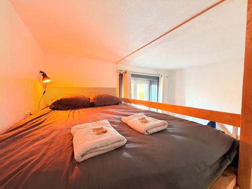 ein Bett in einem Zimmer mit zwei Handtüchern darauf in der Unterkunft Studio - Vue imprenable sur le Doubs in Beure