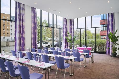 a conference room with tables and chairs and windows at nhow Berlin in Berlin