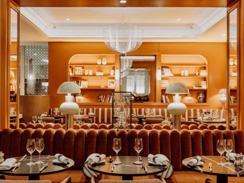 un ristorante con un divano e due tavoli con bicchieri da vino di Sofitel Paris Baltimore Tour Eiffel a Parigi