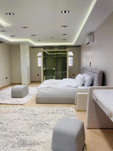 a large bedroom with a large bed with two ottomans at Desert Rose Hotel in Siwa