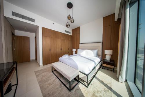 a bedroom with a large white bed and a couch at Luxury 1 Bedroom Canalfront Apartment with Burj Khalifa Views from Resort-Style Pool - Walk to Jumeirah Beach in Dubai