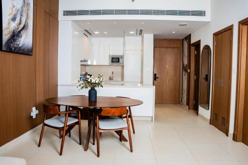 a kitchen and dining room with a wooden table and chairs at Luxury 1 Bedroom Canalfront Apartment with Burj Khalifa Views from Resort-Style Pool - Walk to Jumeirah Beach in Dubai
