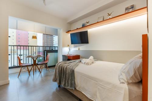une chambre avec un lit et une table avec des chaises dans l'établissement Co. Next Liberdade - Av. Liberdade, à São Paulo