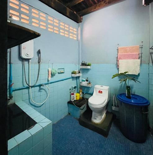 a bathroom with a toilet and a shower with a plant at HostelBed and Retreat Phitsanulok in Phitsanulok