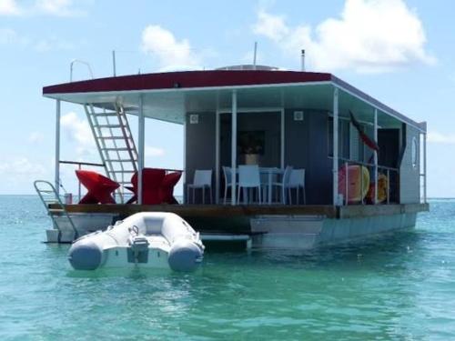 a boat with a house on the water at Aqua Lodge, Les Saintes, Terre de Haut, Guadeloupe in Terre-de-Haut