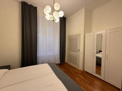 um quarto com uma cama branca e um lustre em Old Town - Best Location Apartment em Taline