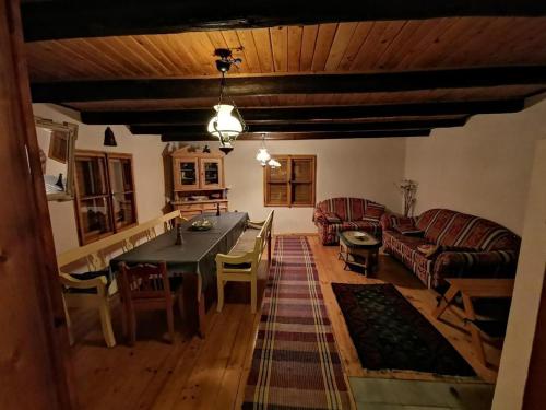 ein Wohnzimmer mit Tisch und Couch in der Unterkunft Traditionelles Bauernhaus TatraWinterparadies in Telgárt