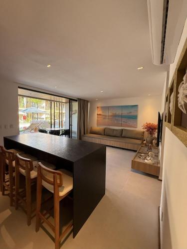 une cuisine avec un îlot noir dans un salon dans l'établissement Beira Mar Naay Porto de Pedras Tatuamunha Palm 10, à Tatuamunha