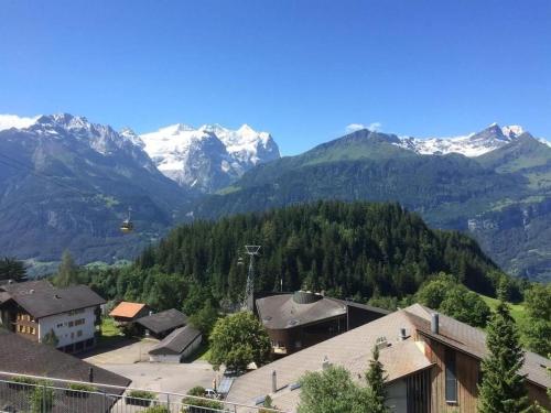 a village with snow capped mountains in the background at Chalet Hofer in Hasliberg Wasserwendi
