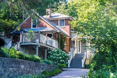 a brick house with a porch and a balcony at Plantation House Bed & Breakfast in Port Hope