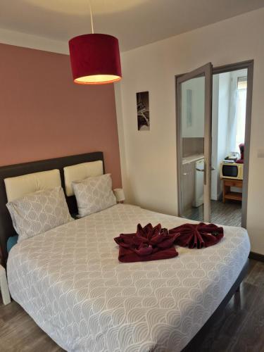 a bedroom with a bed with a red bow on it at 17, face à la gare in Lannion