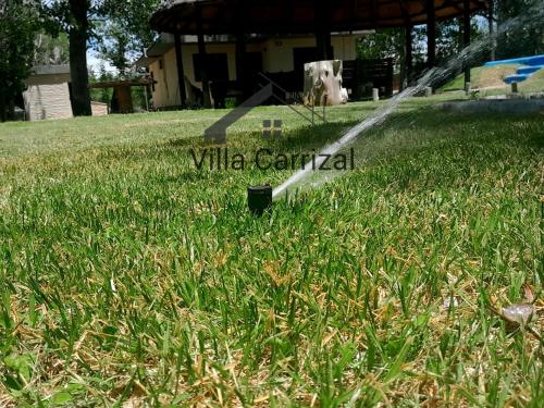 una manguera en el césped en un patio en Villa Carrizal, en Ciudad Lujan de Cuyo
