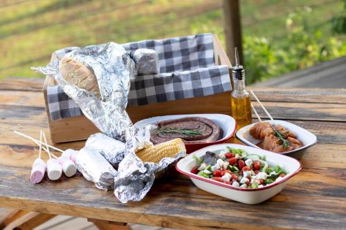 une table avec deux assiettes de nourriture et une salade dans l'établissement AfriCamps at Gowan Valley, à Balgowan