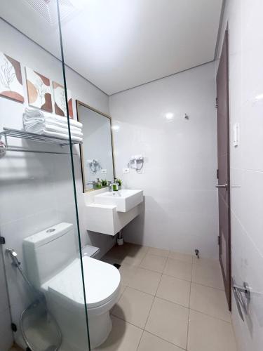 a bathroom with a toilet and a sink at The Banyan Rest in Balibaguhan