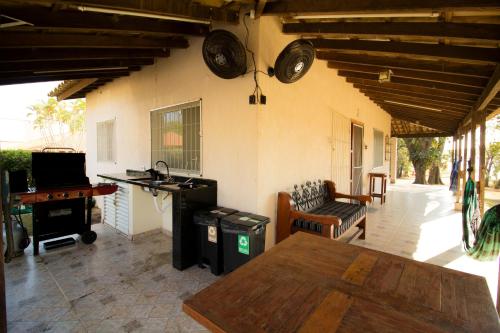 un salon avec une table et un bureau dans l'établissement Casa de Campo em frente ao Lago em Americana-SP, à Americana