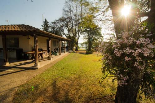un parc avec un pavillon et un arbre fleuri dans l'établissement Casa de Campo em frente ao Lago em Americana-SP, à Americana