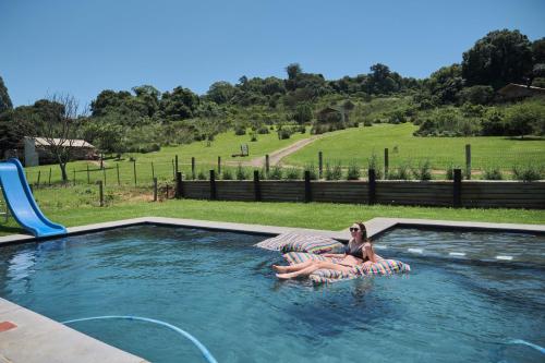 une femme qui se pose sur un radeau dans une piscine dans l'établissement AfriCamps at Gowan Valley, à Balgowan