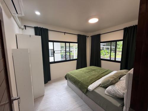 een slaapkamer met een bed en twee ramen bij Green Horizon in Ko Pha Ngan