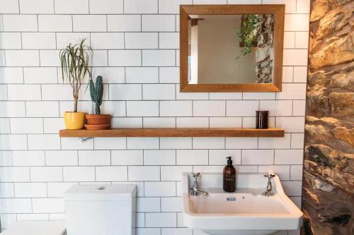 ein Badezimmer mit Waschbecken und Spiegel in der Unterkunft 'Langton' - Best Views in Falmouth! in Falmouth