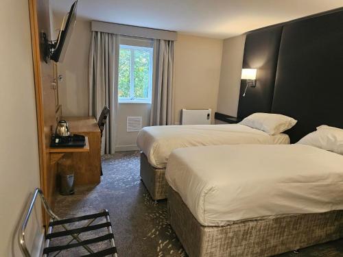 a hotel room with two beds and a window at Wigan Oak Hotel by Belvilla in Wigan