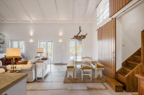a kitchen and living room with a table and chairs at Comporta Sunset Villa by Lovelystay in Comporta