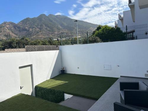 Un edificio blanco con un césped verde encima. en Urban Loft, en Los Llanos de Aridane