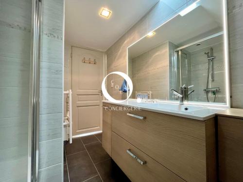 een badkamer met een wastafel en een spiegel bij COC - Les Sables Blancs in Wissant