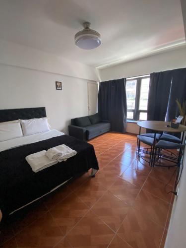 Un dormitorio con una cama y una mesa y sillas. en Apart 408, en Buenos Aires