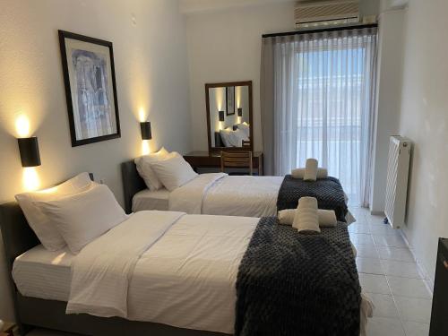 ein Hotelzimmer mit zwei Betten und einem Spiegel in der Unterkunft Therma Hotel in Loutra Ipatis