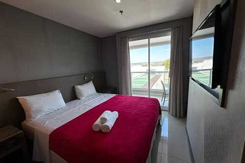 a bedroom with a bed with two white towels on it at Brisas do Lago - Estadia com ALMA in Brasília