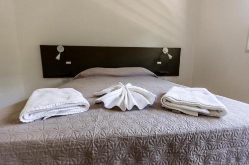 a bed with towels on top of it at BUENA VIDA I Apart Hotel in Villa Icho Cruz