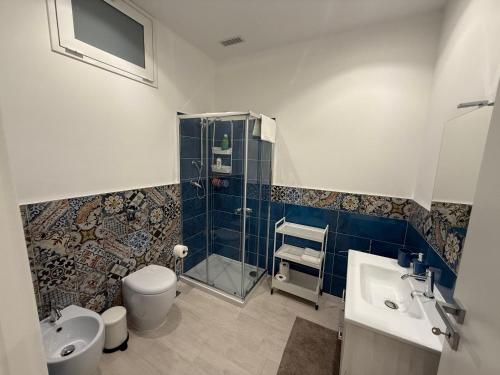 a bathroom with a shower and a toilet and a sink at Maison Rovaga in Ispica