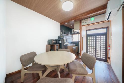 a dining room with a white table and chairs at Takumi Renovated House Osaka Hirakata in Hirakata