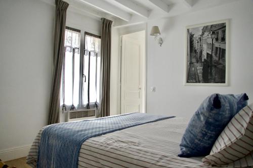 ein Schlafzimmer mit einem Bett mit blauen Laken und einem Fenster in der Unterkunft Le Cabanon in Cosne Cours sur Loire