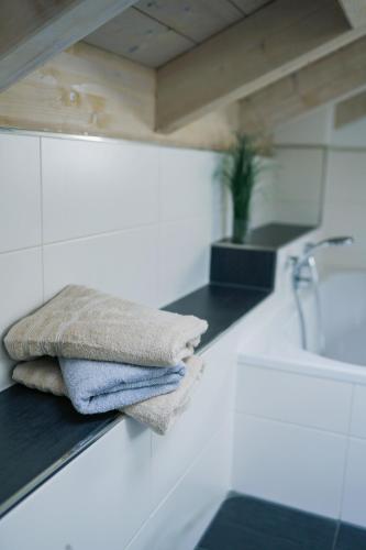 a pile of towels sitting on a counter in a bathroom at Lichtdurchflutete Wohnung mit großer Dachterrasse in Bruckmühl