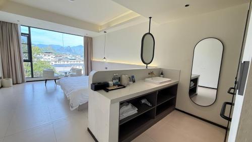 XingpingにあるBanshanyue Hotel, Yangshuoのベッドと洗面台と鏡のある寝室