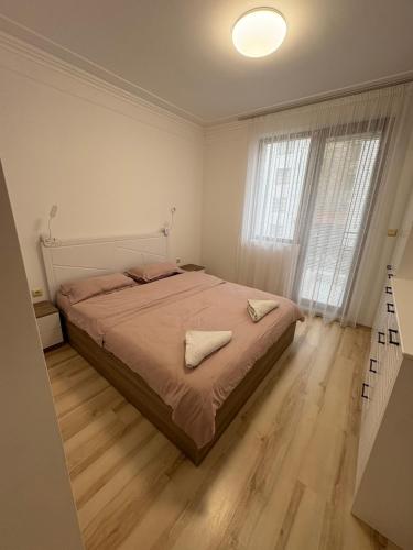 een slaapkamer met een bed en een groot raam bij Ravda Apolon 9 Apartment in Ravda