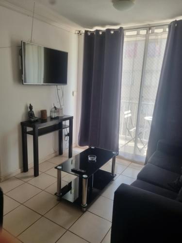 a living room with a couch and a table and a tv at Departamento elsa ramitez in Ovalle