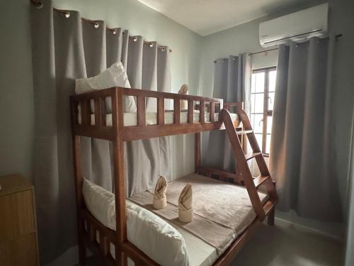 a wooden bunk bed with shoes on the bottom bunk at Surfers Shell Dahican in Dahikan