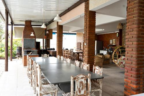 une salle à manger avec une grande table et des chaises dans l'établissement Pousada CASA BELA mar, à Itanhaém