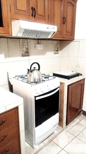 d'une bouilloire et d'une cuisinière dans la cuisine. dans l'établissement Departamento con Estacionamiento Tacna, à Tacna